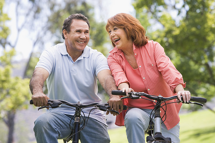 Happy couple riding bikes outside in nature