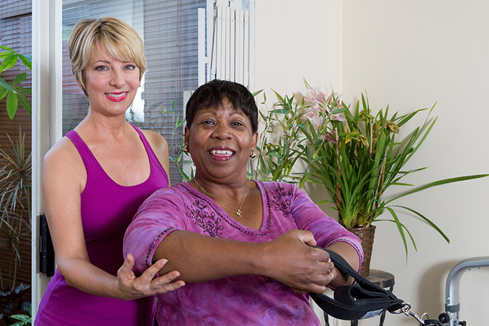 Patte James with injury rehabilitation client doing shoulder and chest exercises on the Reformer